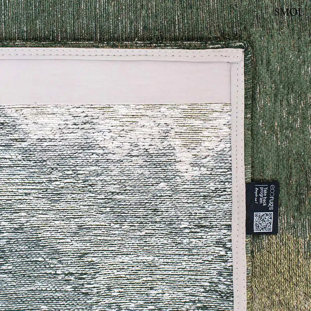 ECO RUG PALM GREEN szőnyeg, sötétzöld színátmenettel, egyik oldalon szinte fehérbe olvadó, mohaszerű tintafolt mintázattal, felhajtott sarokkal, alulról