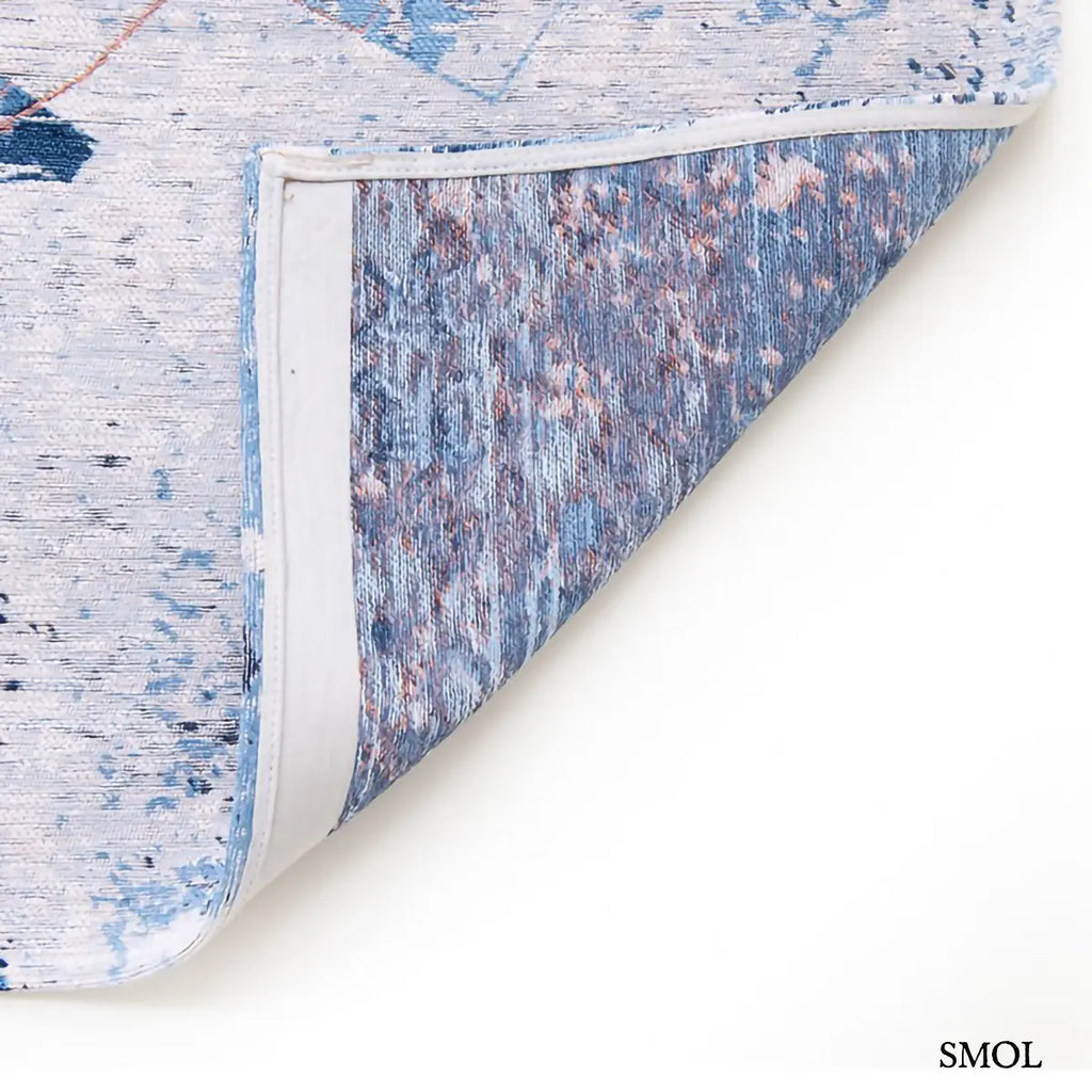 ECO RUG CONDUCTIVE BLUE városkép mintás szőnyeg kék alapon bronz és fehér akcentusokkal, absztrakt festői hatással, felhajtott sarokkal