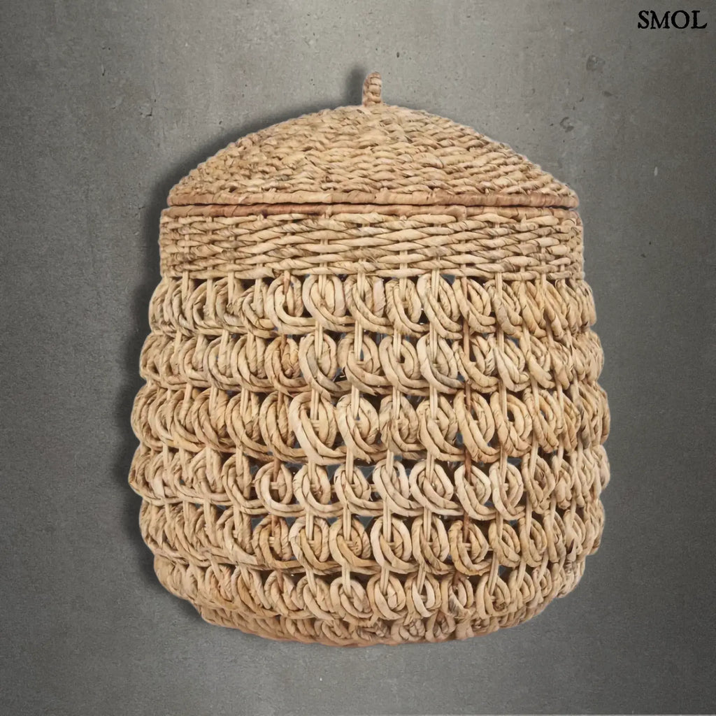 Kézzel fonott banánlevél tároló kosár fedővel, természetes natúr színben. Magas, kerek, szürke háttérrel
