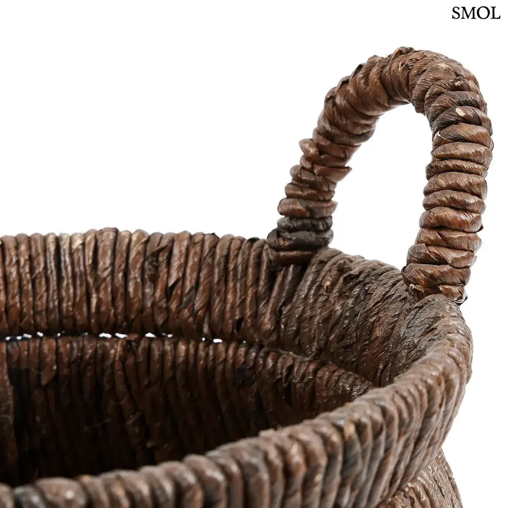 Kézzel font, sötétbarna banánlevél tárolókosár felfelé szűkülő háromszög alakú dizájnnal és masszív fogantyúkkal, fogantyú nagyítva