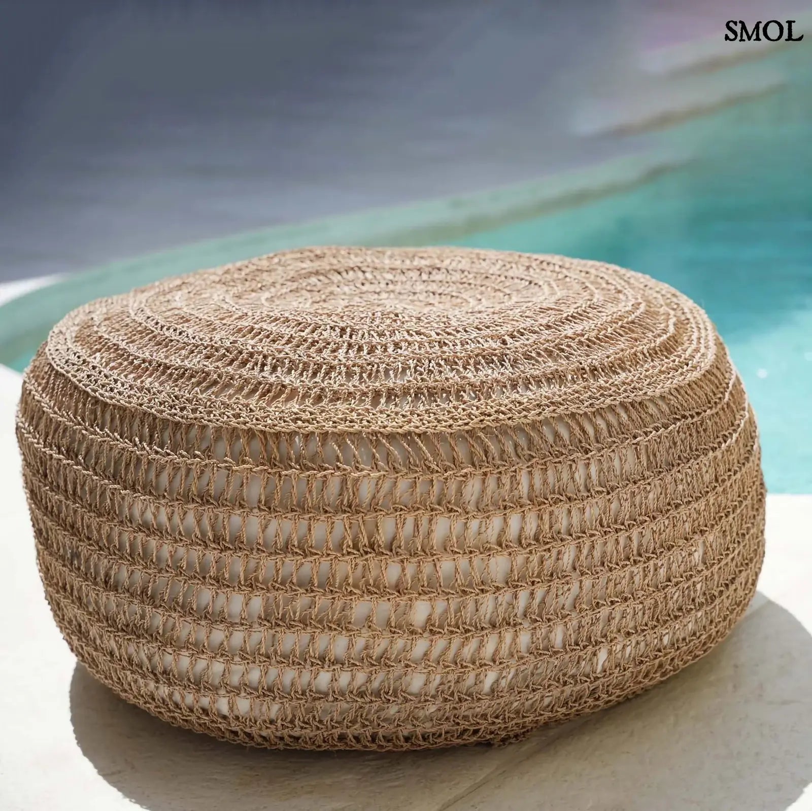 Kézzel fonott, natúr tengerifű puff (ülőke), kerek formájú, vastag fonással oldalról, medence mellett