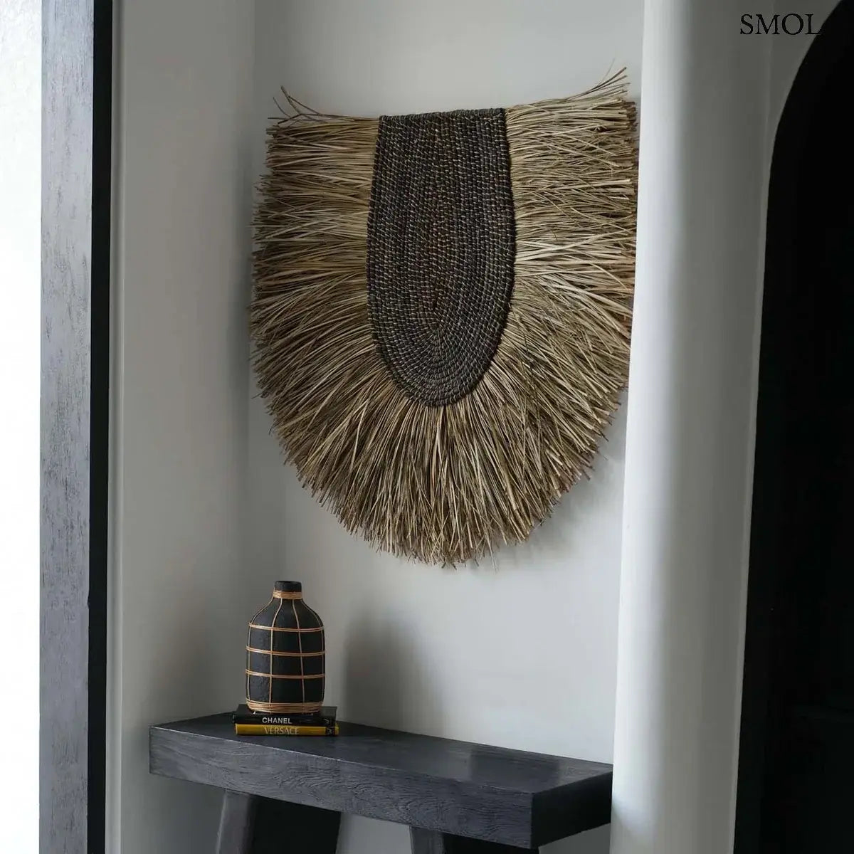 Terracotta váza fekete színben, natúr rattan fonással díszítve, konzolasztalon