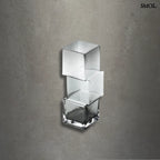 Függőlegesen elrendezett, három kocka alakú sötétszürke üveg váza, szürke háttérrel