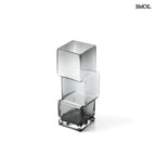 Függőlegesen elrendezett, három kocka alakú sötétszürke üveg váza, fehér háttérrel