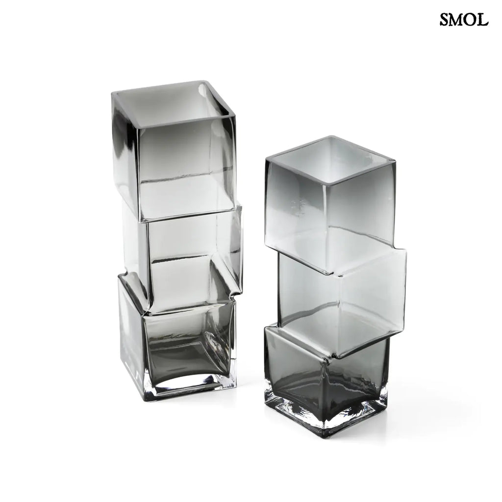 Függőlegesen elrendezett, három kocka alakú sötétszürke üveg váza, felülről