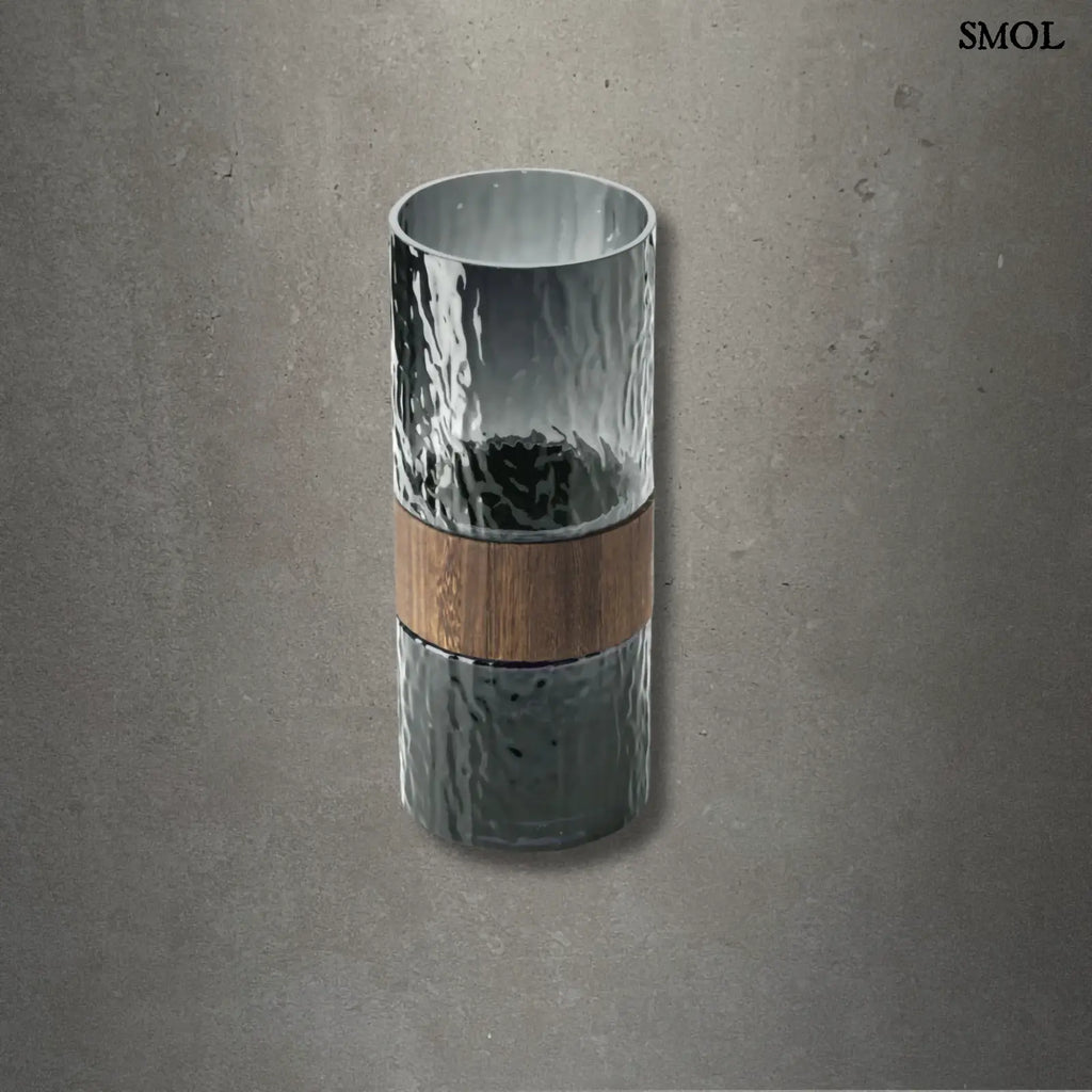 Sötétszürke váza üvegből, középen fa berakással, modern díszítőelem, szürke háttérrel