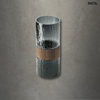 Sötétszürke váza üvegből, középen fa berakással, modern díszítőelem, szürke háttérrel