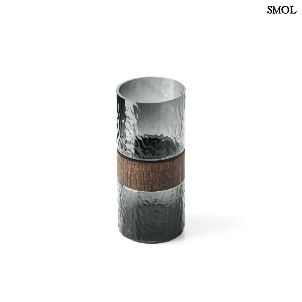 Sötétszürke textúrált üveg váza, barna fa berakással, felülről