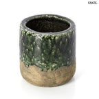 Rusztikus, henger alakú kerámia kaspó, alsó részén nyers barna agyaggal, felső részén pedig sötétzöld, rücskös mázzal, fehér háttérrel