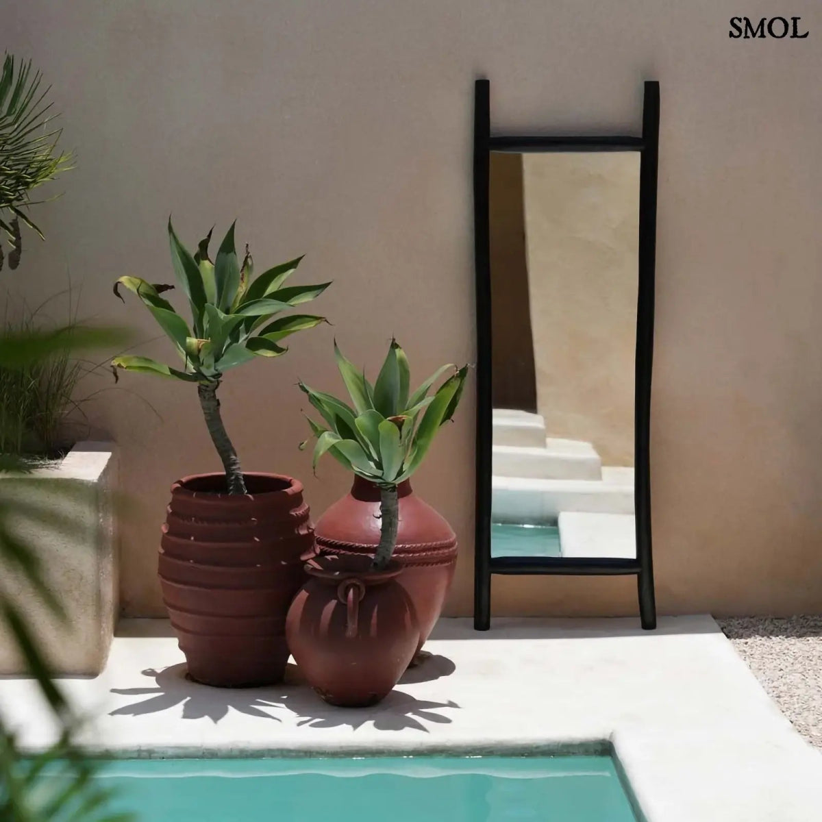 állótükör fekete teakfa keretben medence mellett kaspókkal