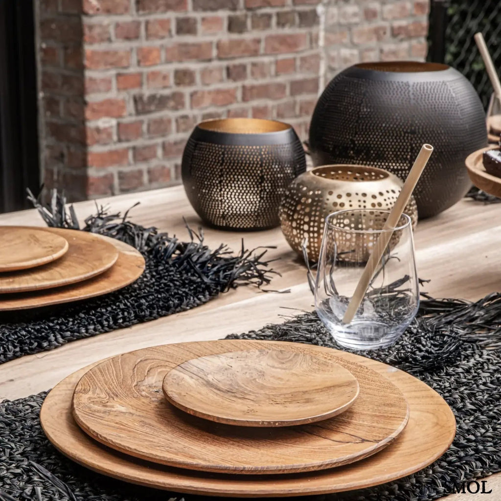 Arany gyertyatartó perforált mintával, meleg fényhatással más gyertyatartókkal, étkezőasztalon