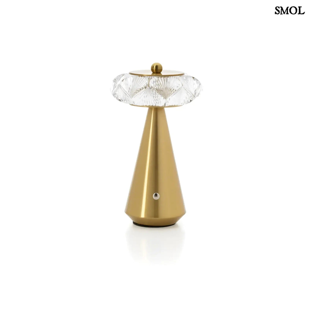 Arany színű, kúpos talapzatú, modern asztali lámpa fehér háttérrel