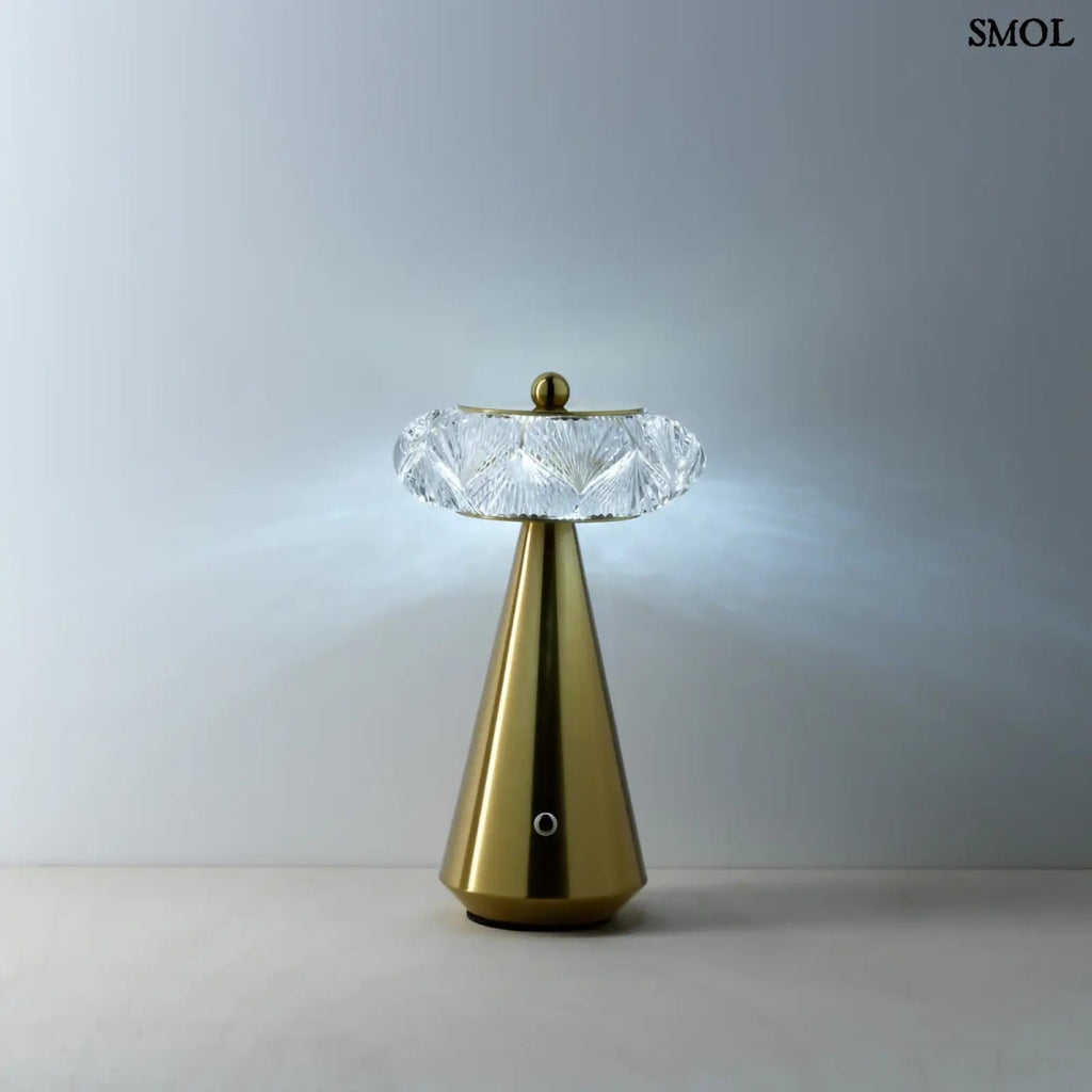 Arany színű, kúpos talapzatú, modern asztali lámpa lágy fénnyel