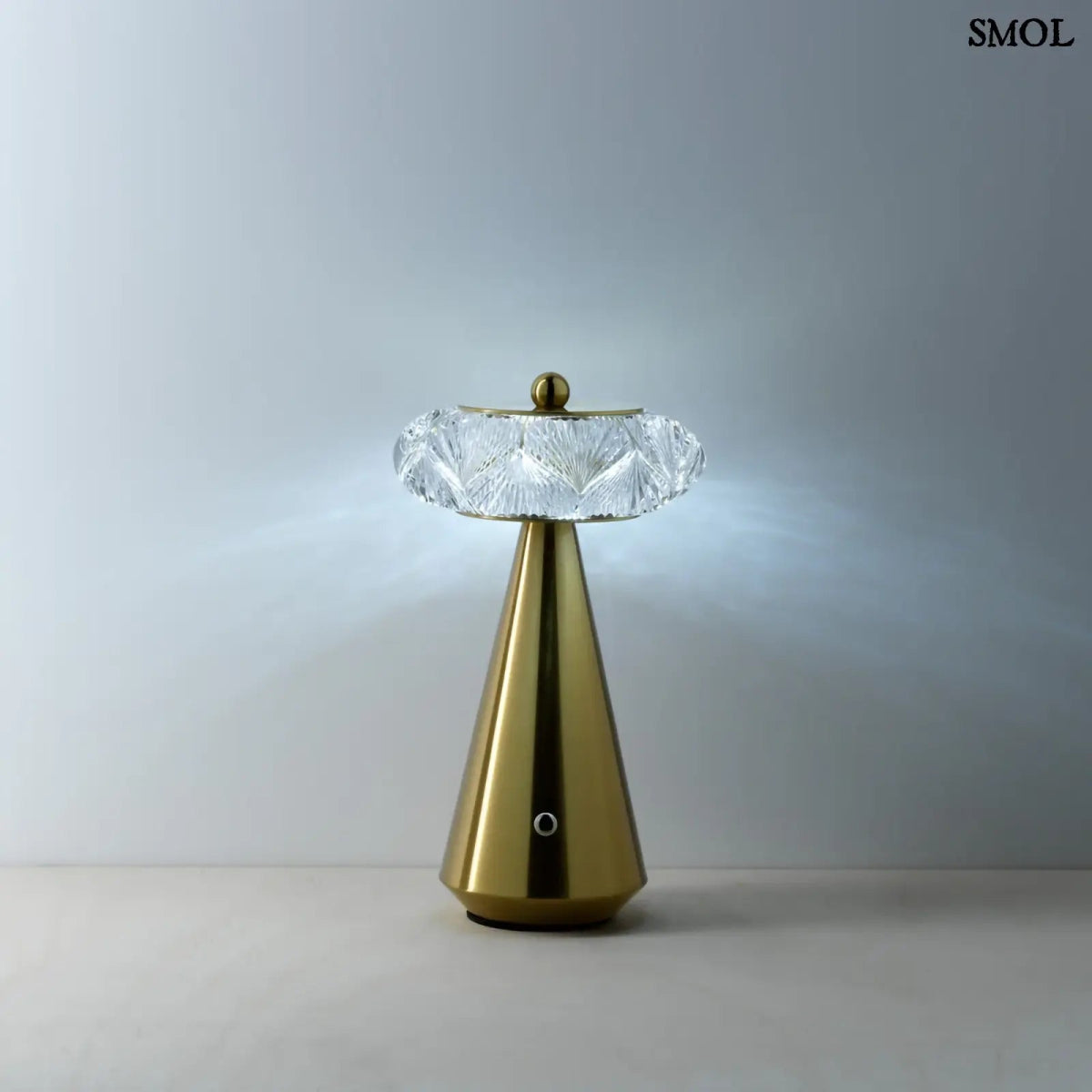 Arany színű, kúpos talapzatú, modern asztali lámpa lágy fénnyel