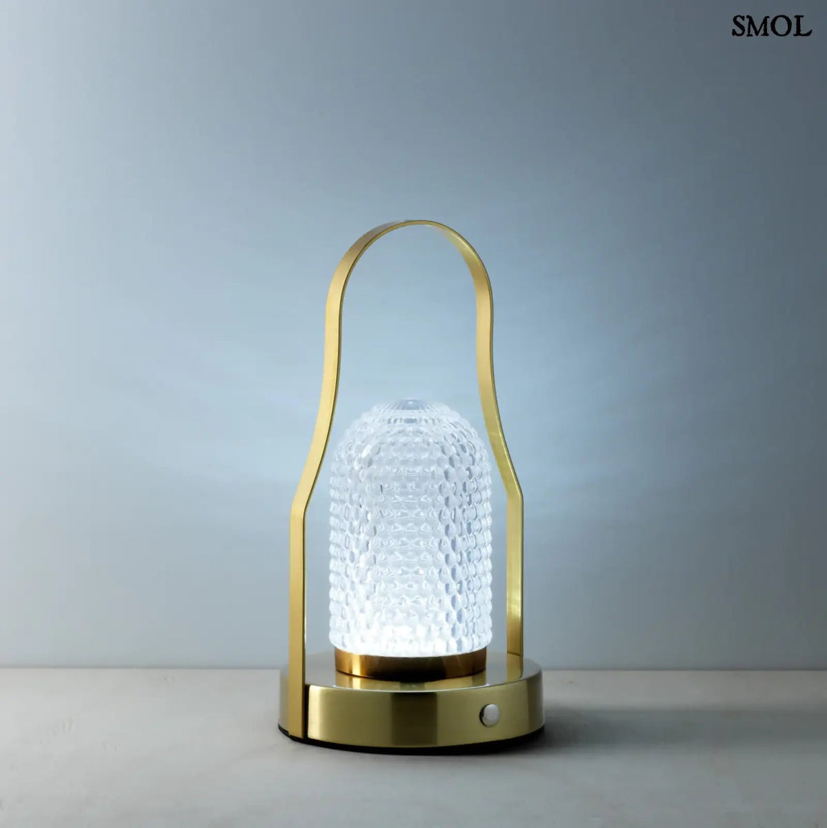 Hordozható LED asztali lámpa arany (brass) színű vázzal és fogantyúval, valamint texturált üveg búrával, kékes fénnyel