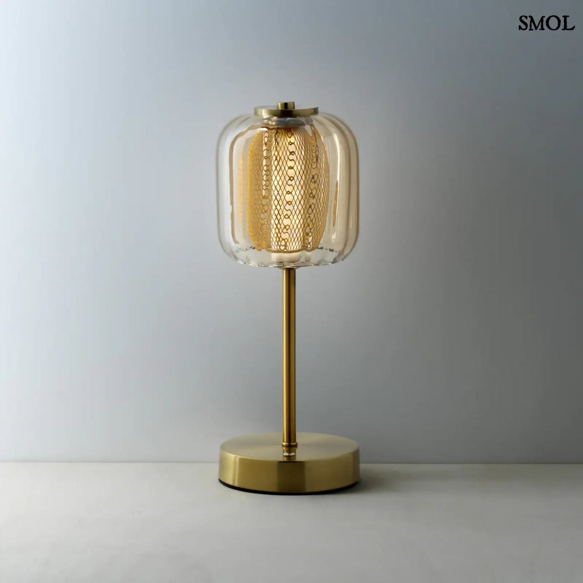 Lighty Gaga asztali lámpa sárgaréz állvánnyal és bordázott borostyán üveg búrával. Vezeték nélküli, hordozható LED közepes fénnyel