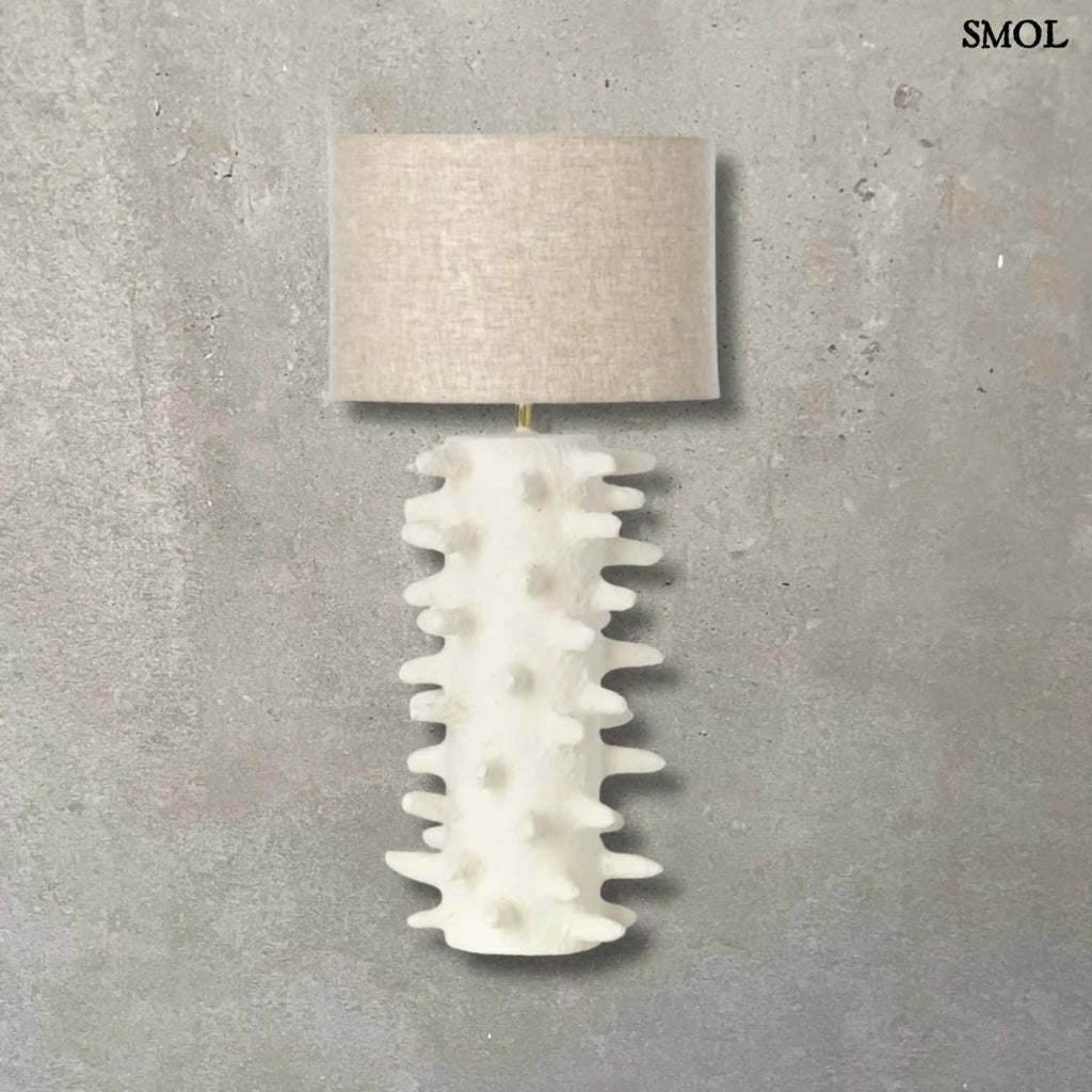 Fehér papírmasé asztali lámpa texturált, tüskés talppal és bézs lámpaernyővel natúr háttérrel