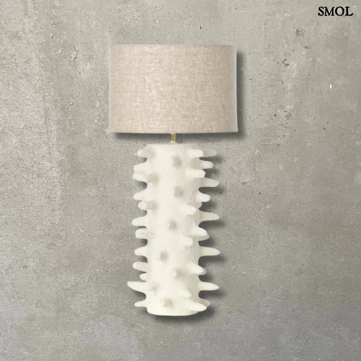 Fehér papírmasé asztali lámpa texturált, tüskés talppal és bézs lámpaernyővel natúr háttérrel