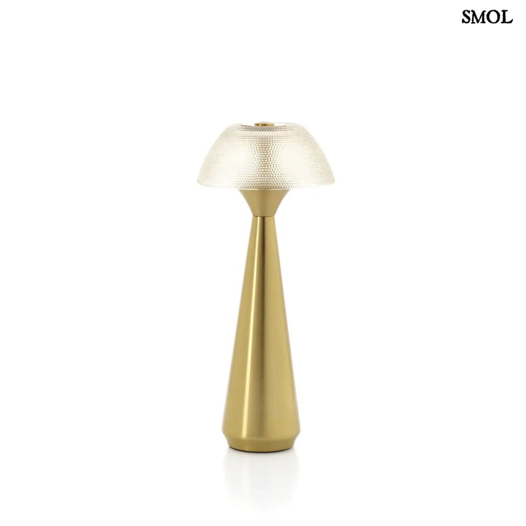 Vezeték nélküli asztali lámpa sárgaréz alappal és textúrált gomba búrával, fehér háttérrel