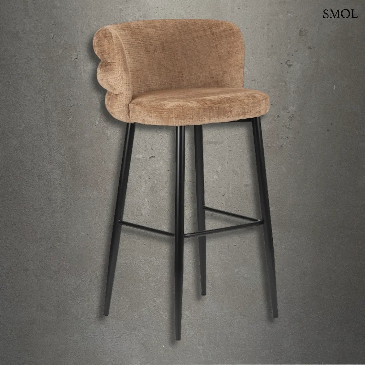 Modern, karamell színű kárpitozott bárszék háromszintes, kagylóformájú háttámlával és karcsú, fekete fém lábakkal, beton hatású háttér előtt.