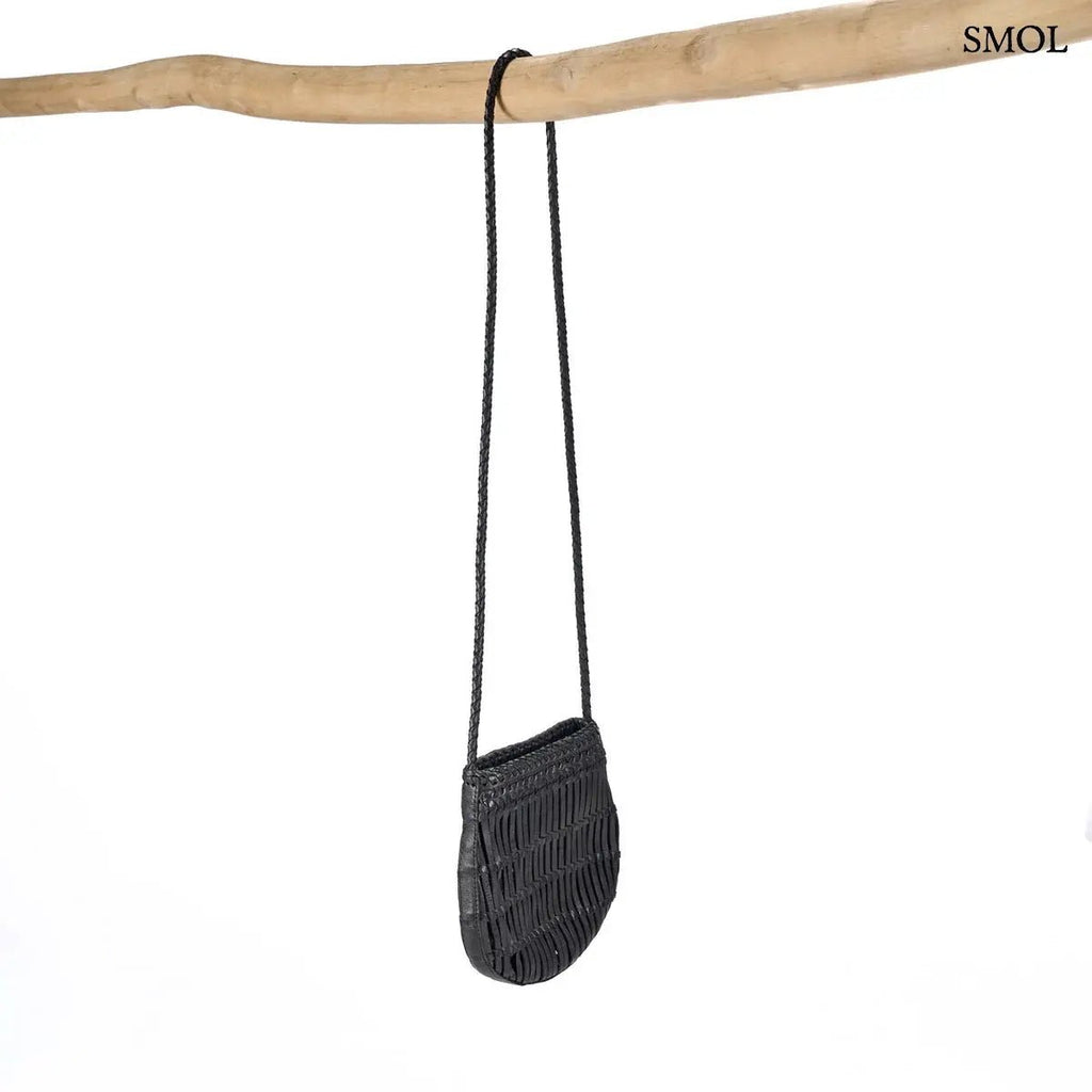 Kézzel font fekete bőr oldaltáska hosszú, fonott keresztpánttal, rúdra akasztva