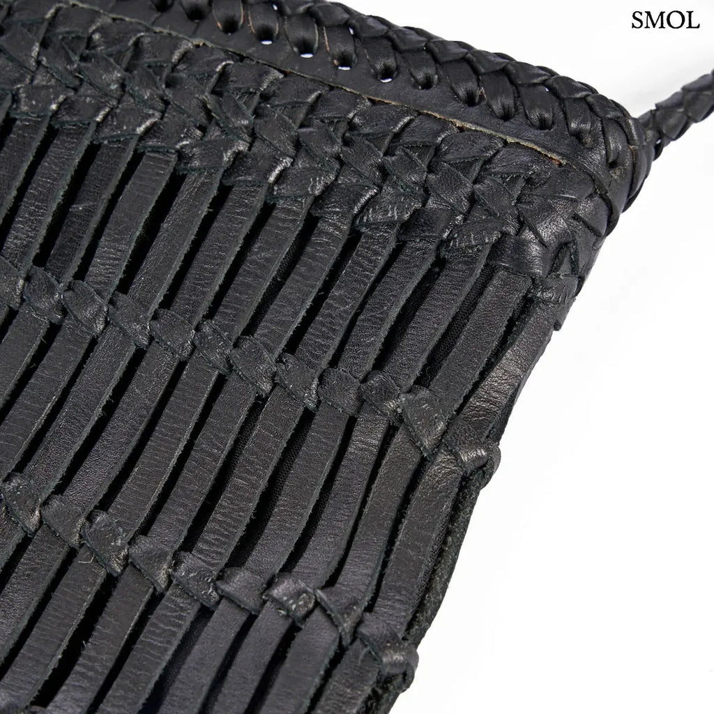 Fekete fonott bőr oldaltáska kézzel készült textúrával és hosszú vállpánttal, oldalról nagyítva