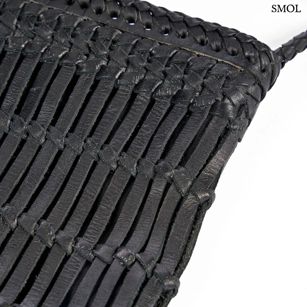 Fekete fonott bőr oldaltáska kézzel készült textúrával és hosszú vállpánttal, oldalról nagyítva