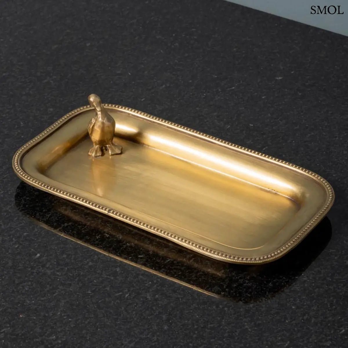 Antik arany sárgaréz dísztál ékszereknek, sarkában kis kacsa figurával, ferdén