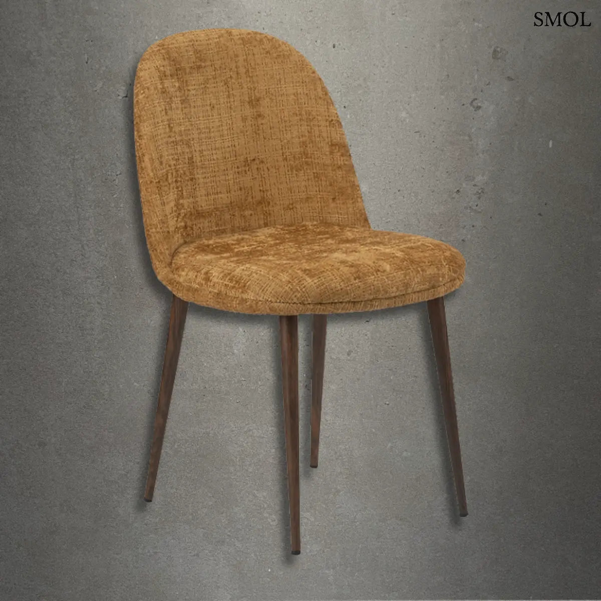 Modern Egg Gold kárpitozott étkezőszék aranybarna strukturált szövettel és sötétbarna fém lábakkal, szürke betonhatású háttér előtt.