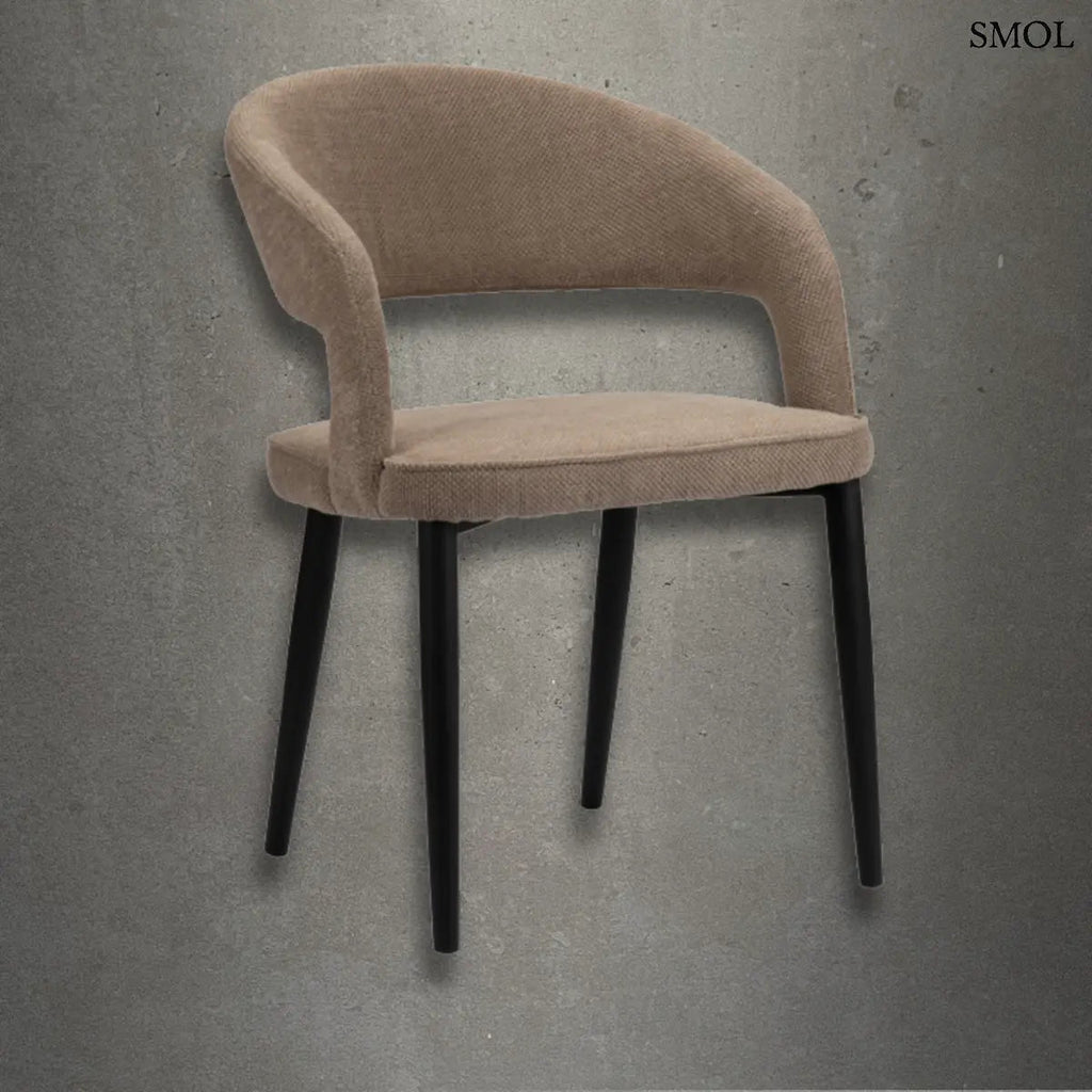 Modern, íves háttámlájú TUSK BROWN étkezőszék barna kárpittal és elegáns, vékony fekete fém lábakkal, betonszürke háttér előtt.