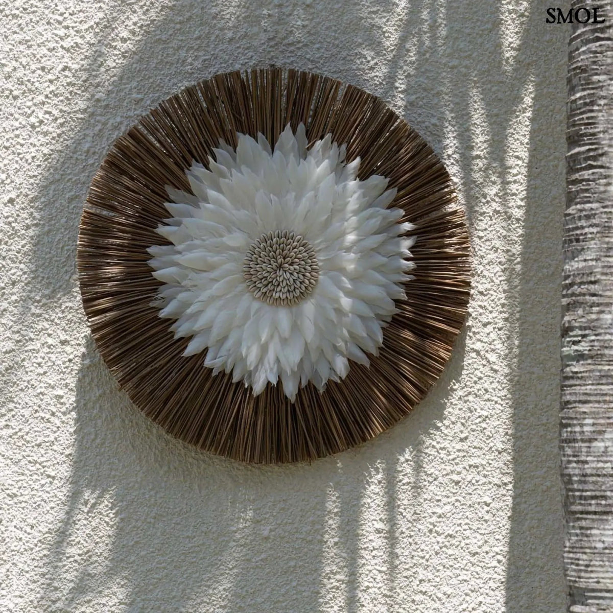 Fali dekoráció fehér tollakkal és kagylós középpel, natúr alang-alang fű alapon, falon