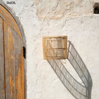 Natúr színű rattan lámpaernyő félhenger formában ajtó mellett