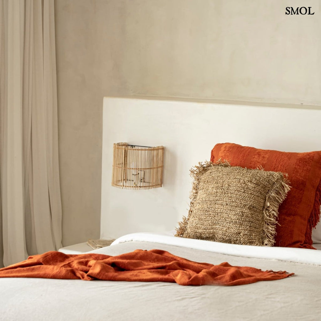 Natúr színű rattan lámpaernyő félhenger formában ágy mellett