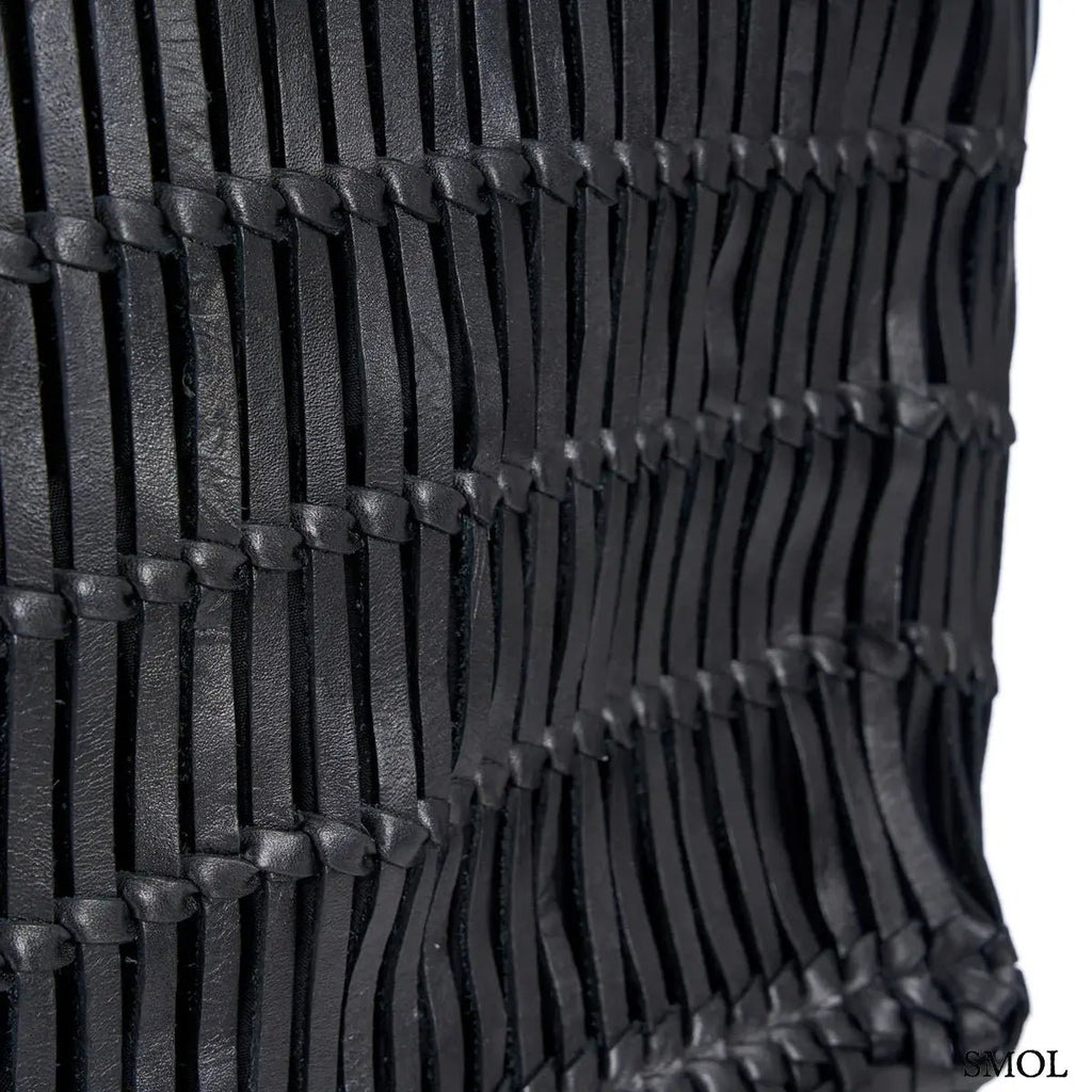 Kézzel fonott fekete bőr táska elegáns textúrával, hosszú vállpánttal és tágas kialakítással, oldalról