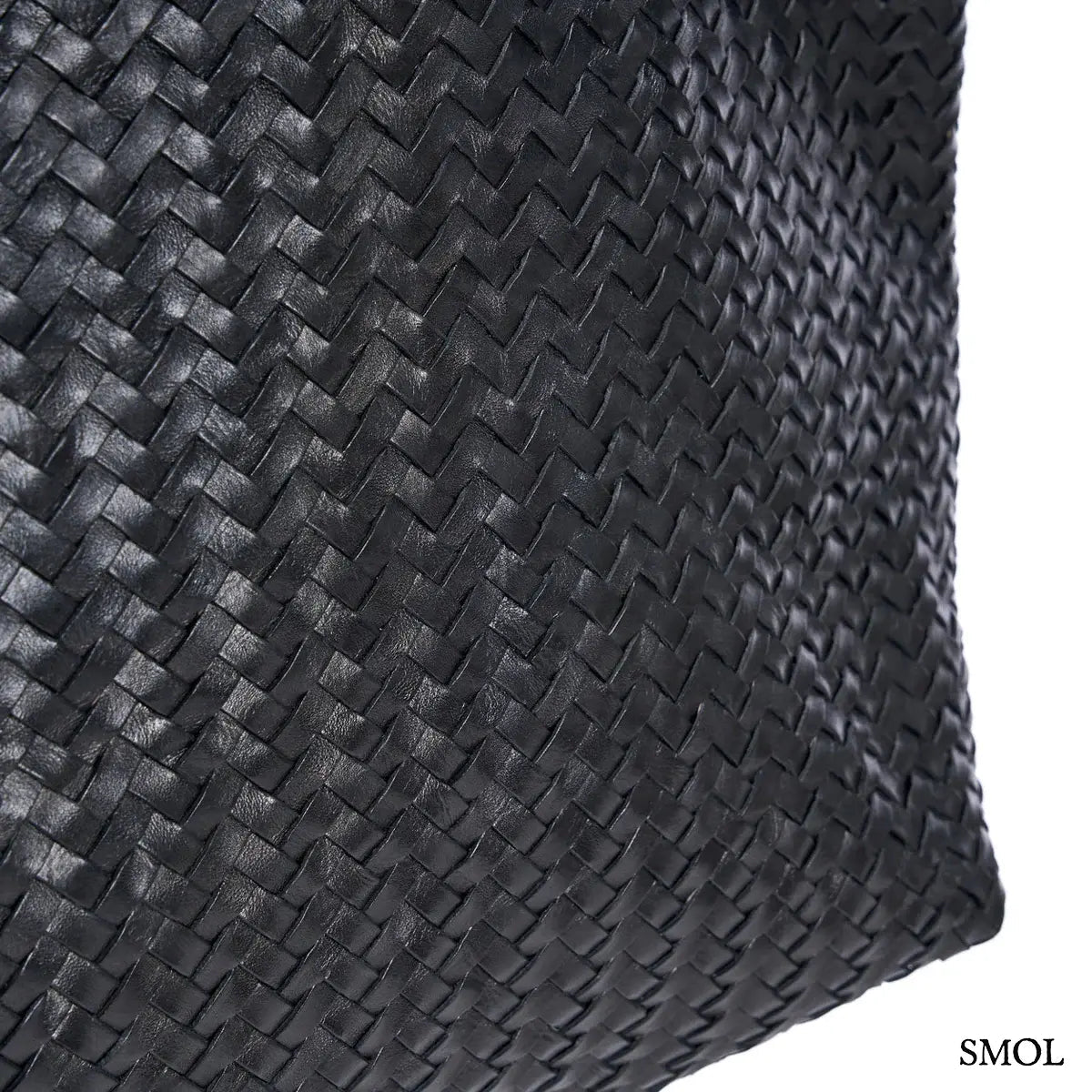 Fekete fonott bőr válltáska és óriás pakolós táska elegáns, kézzel készített textúrával, nagyítva oldalról