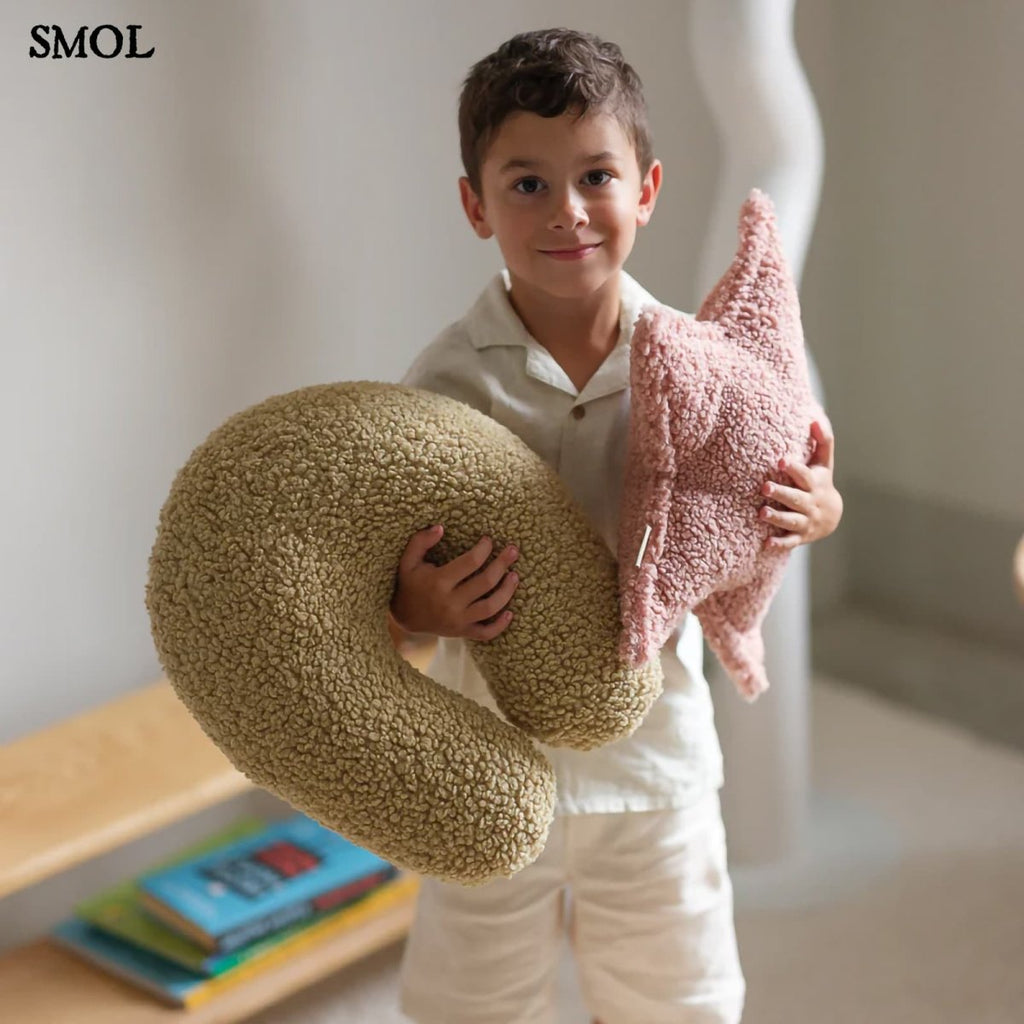 Gyerek csillagpárna | GLORI , csillag alakú, teddy anyagú gyerekpárna - SMOL - U-alakú párnával, gyerek kezében