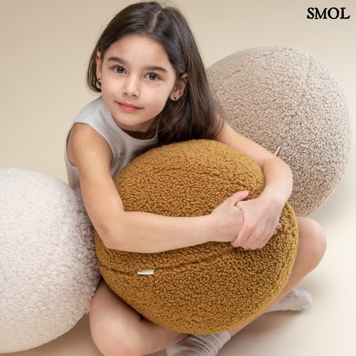 Gyerek labdapárna | BISCUIT, teddy anyagú, gyerekpárna,⌀ 35 cm -SMOL - labdapárnát ölelő gyerekkel, több színben