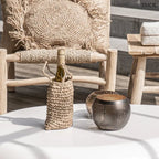 Fekete és arany színű, lyukacsos mintájú fém gömb gyertyatartó, kisasztalon