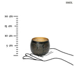 Fekete és arany színű, lyukacsos mintájú fém gömb gyertyatartó, méretarányosan