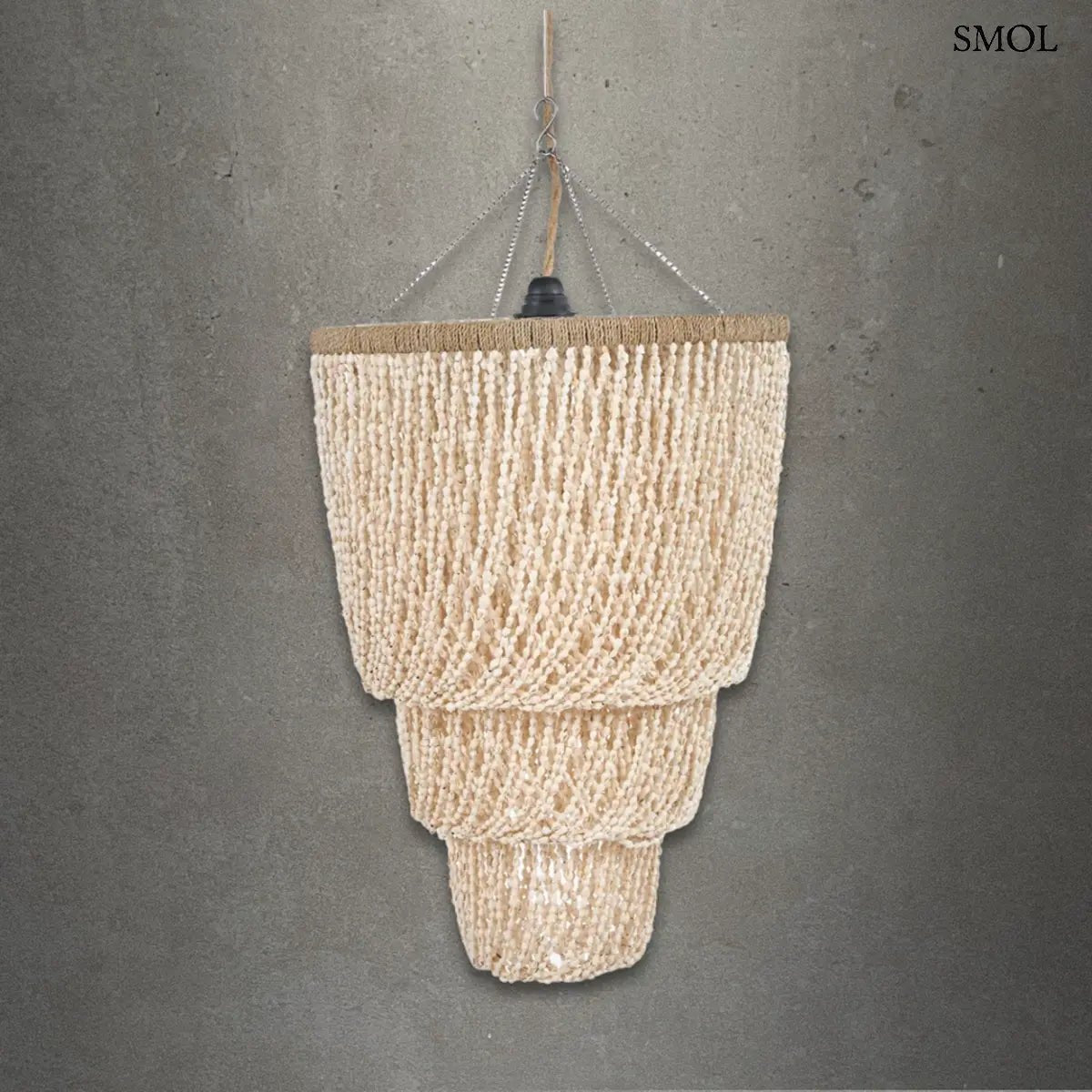 Háromszintes, vízesés formájú kézműves függőlámpa fehér tengeri kagylókból, természetes textúrával és fém vázzal, szürke háttérrel