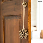 Barna kagyló függődísz, kézműves bojt formában, natúr kötélre akasztva ajtóra akasztva