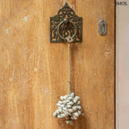 Kézzel készült, szürke színű kagyló függődísz sodrott kötéllel, kilincsen