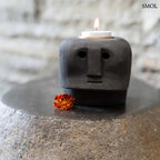 Kézzel faragott fekete kő mécsestartó misztikus arc szobor formában, sárgaréz betéttel, égő mécsessel