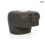 Kézzel faragott fekete kő mécsestartó misztikus arc szobor formában, sárgaréz betéttel, elforgatva