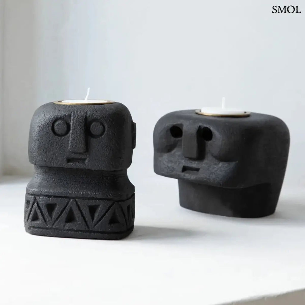 Fekete kő mécsestartó, kézzel faragott stilizált arc motívummal, Sumba-szigeti homokkőből, fekete mécsestartóval