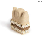 Kézzel faragott Sumba kőszobor homokkőből, fehér cowrie kagyló díszítéssel és rusztikus kötéllel, ferdén