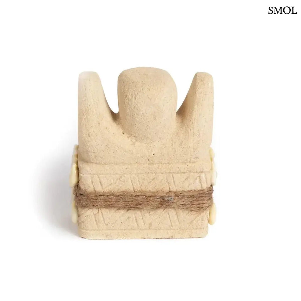 Kézzel faragott Sumba kőszobor homokkőből, fehér cowrie kagyló díszítéssel és rusztikus kötéllel, hátulról