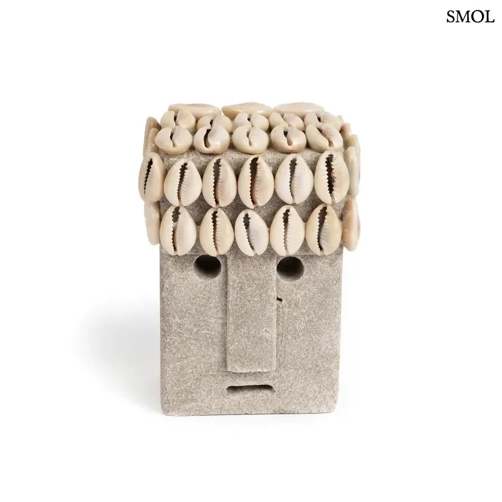 Kézzel faragott szürke Sumba kőszobor valódi kagyló díszítéssel és absztrakt arccal, fehér háttérrel