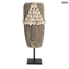 Kézzel faragott homokkő szobor kagylódíszekkel, fekete fém talapzaton, szemből