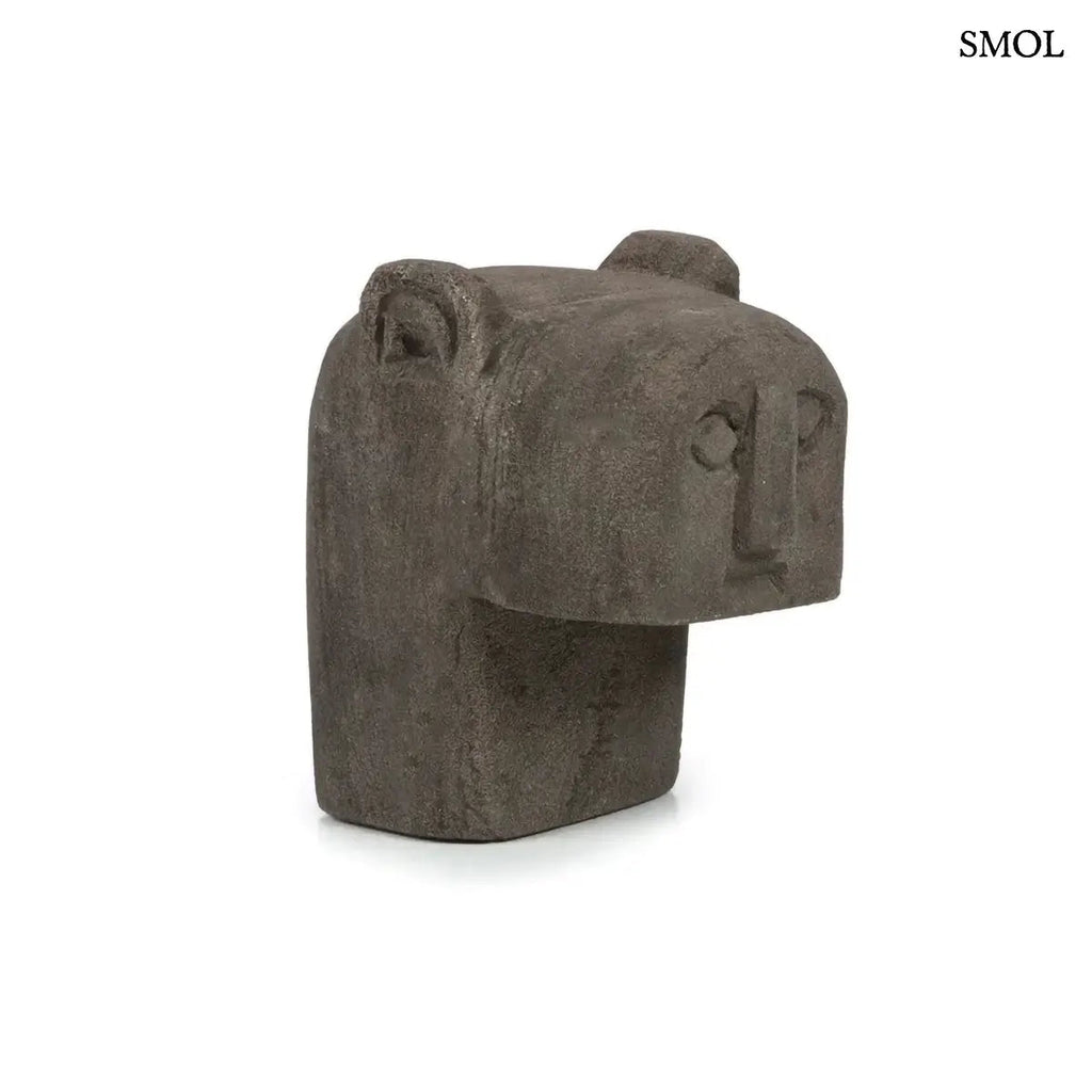 Kézzel faragott szürke homokkő szobor Sumba szigetéről, minimalista arcvonásokkal és hegyes fülekkel, ferdén